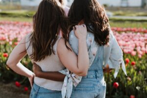 friends-hugging-and-looking-at-roses-outside