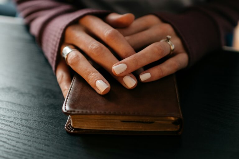 ladys hands resting on a Bible for morning prayer