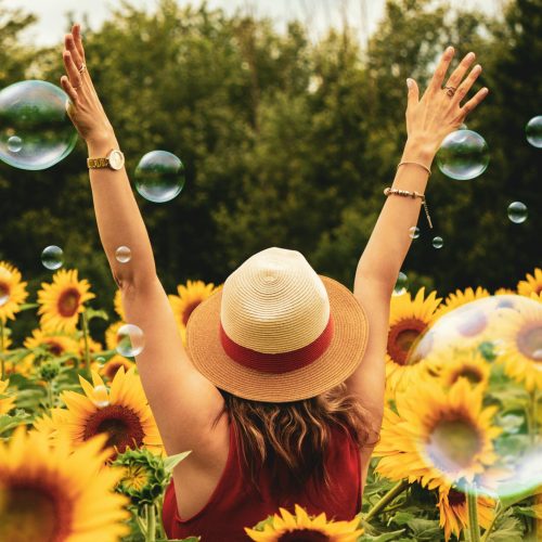 pexels-photo-1263986-1263986 A joyful woman in a sunflower field with bubbles, expressing happiness on a summer day.